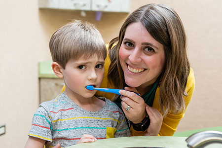 Mom and Daughter brushing their teeth - Pediatric Dentists